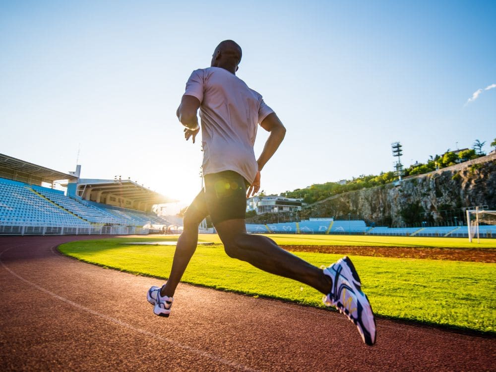 Coureur en pleine course sur piste pour illustrer une fausse activité Strava réaliste