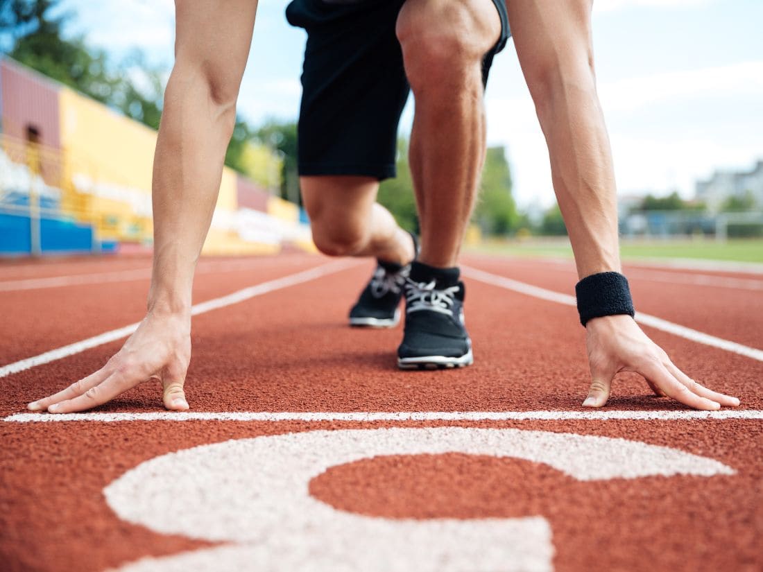 Runner on a track ready to start, symbolizing fake my run concept